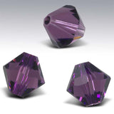 Three purple faceted beads on a gray background