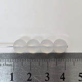 matte opalite glass round beads on a pin with a ruler for scale