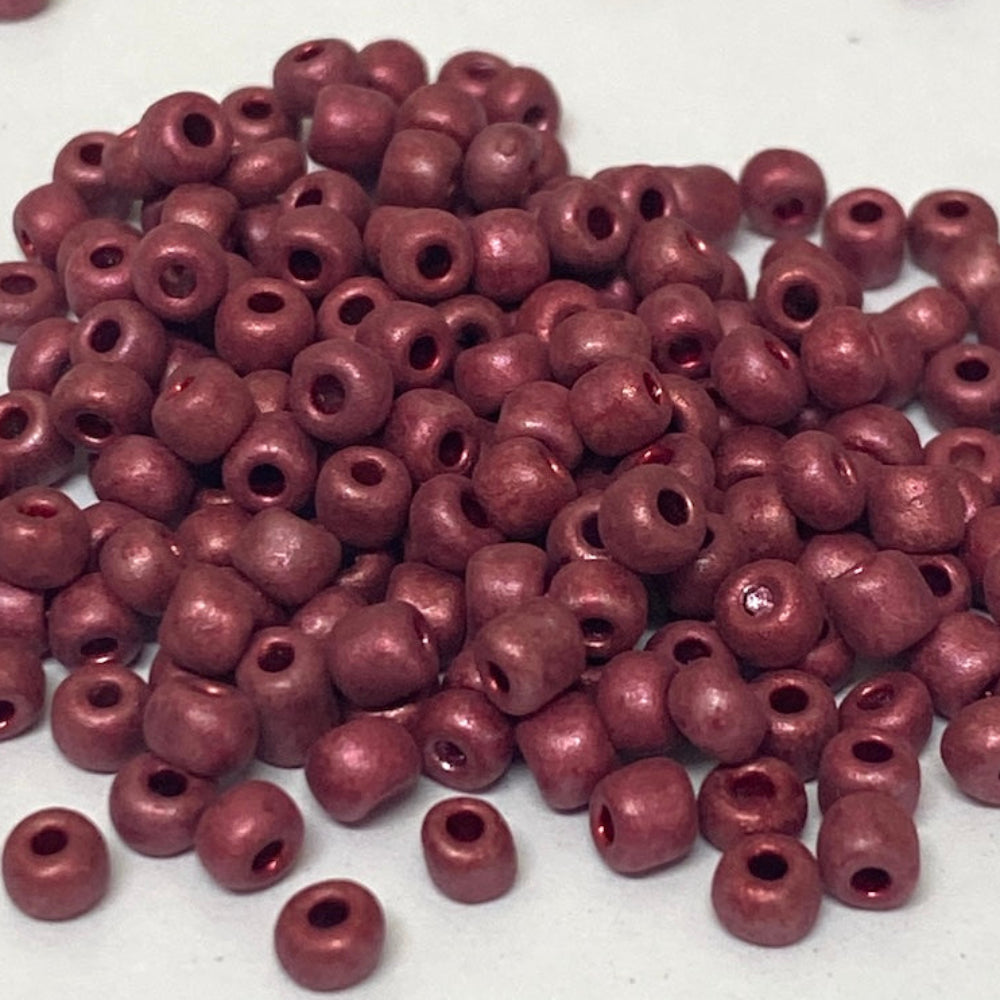 Maroon beads scattered on a white background