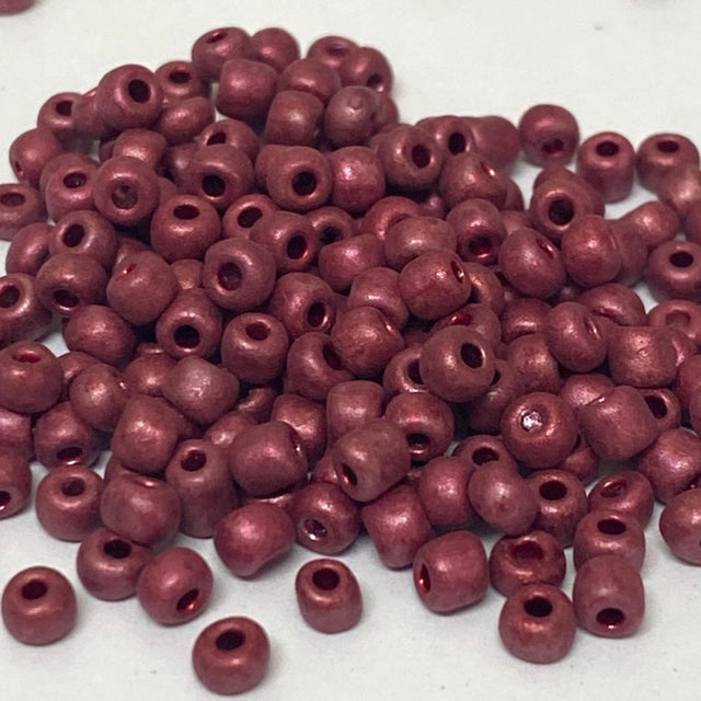 Maroon beads scattered on a white background