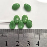 Green leaf-shaped objects with a ruler for scale on a white background
