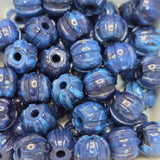 Blue stone look beads with textured surface on a white background