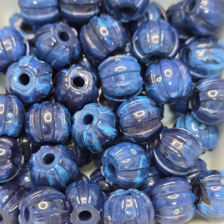 Blue stone look beads with textured surface on a white background