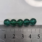 Green beads on a ruler for size reference