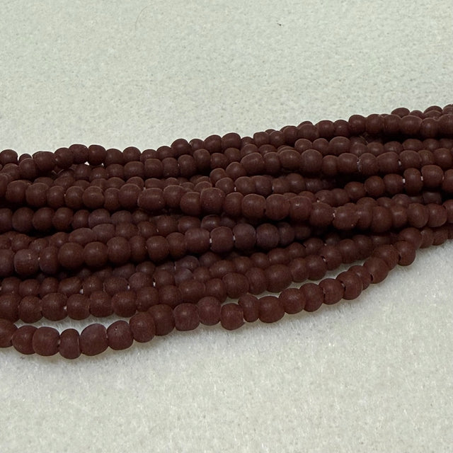 Strings of chocolate brown round beads on a light gray background