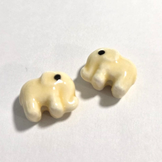 two yellow elephant beads made from ceramic porcelain on a white background