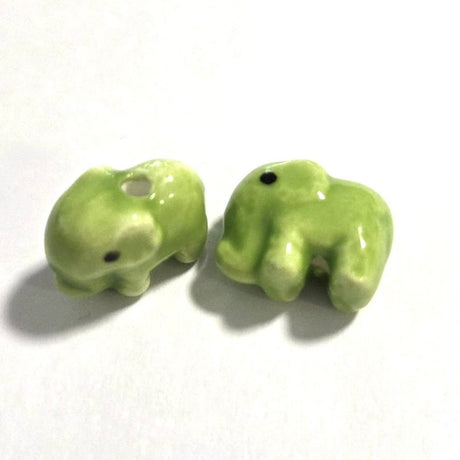 Two small green ceramic elephants on a white background