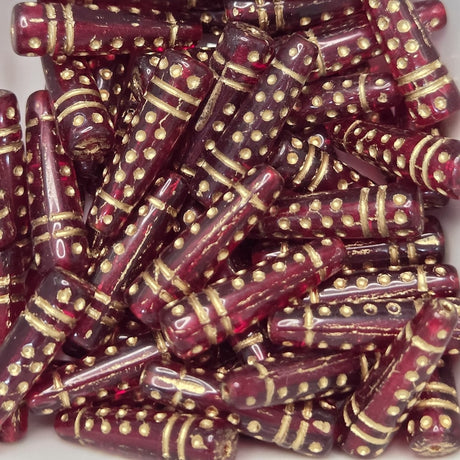 Burgundy cone shape beads with gold accents arranged on a white background