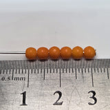 Orange beads on a ruler for size measurement