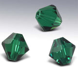 Three green faceted crystal beads on a white background