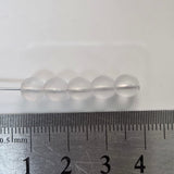 matte transparent glass round beads on a pin with a ruler to show size