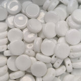 Close-up of white flat round beads with a glossy finish.