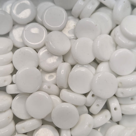 Close-up of white flat round beads with a glossy finish.