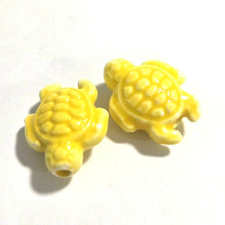 Two yellow turtle-shaped objects on a white background