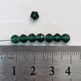 Green beads on a ruler for size reference