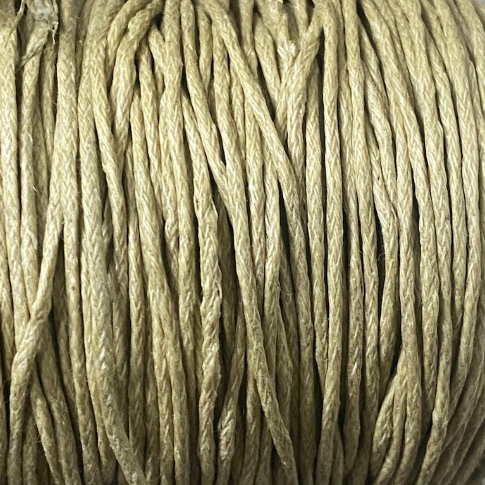 Close-up of a spool of beige cord on a white background