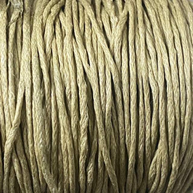 Close-up of a spool of beige cord on a white background