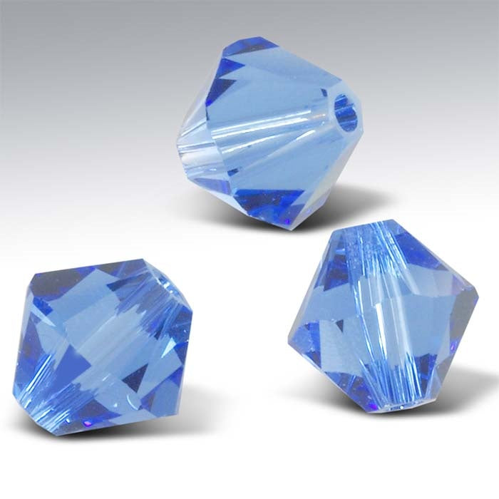 Three blue crystal beads on a gray background