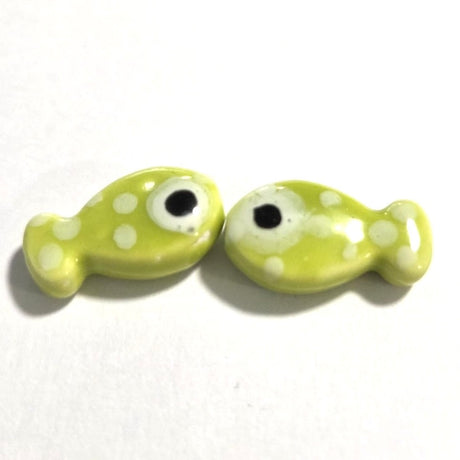 two lime green ceramic fish beads with white polka dots and black eyes
