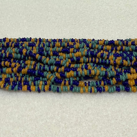 Mix Teal/Mustard/Blues color mini glass donut beads on strands on a cream background