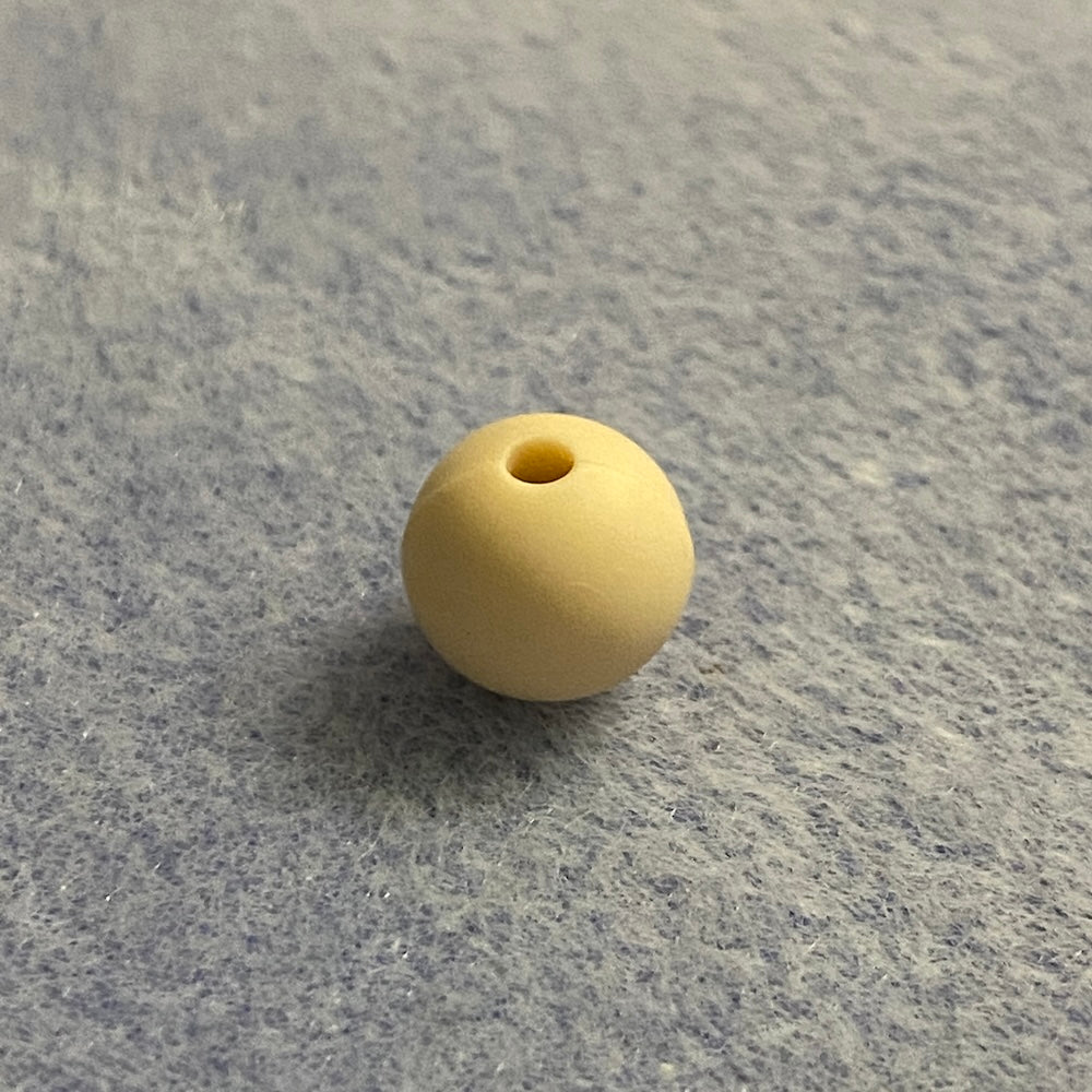 neutral nude colour silicone bead on a gray textured surface