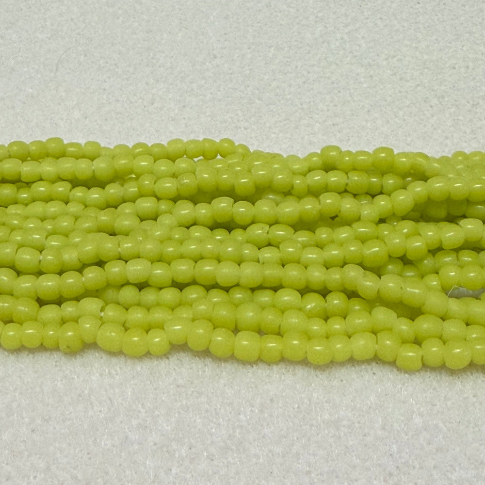 Strings of limey yellow round beads on a light gray background