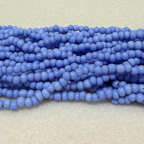 Strings of blue round beads on a light gray background