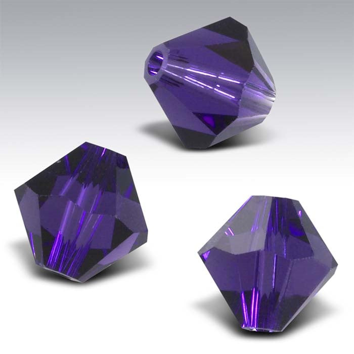 Three purple faceted crystals on a gray background