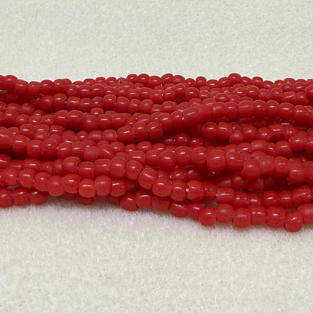 Strings of red round beads on a light gray background
