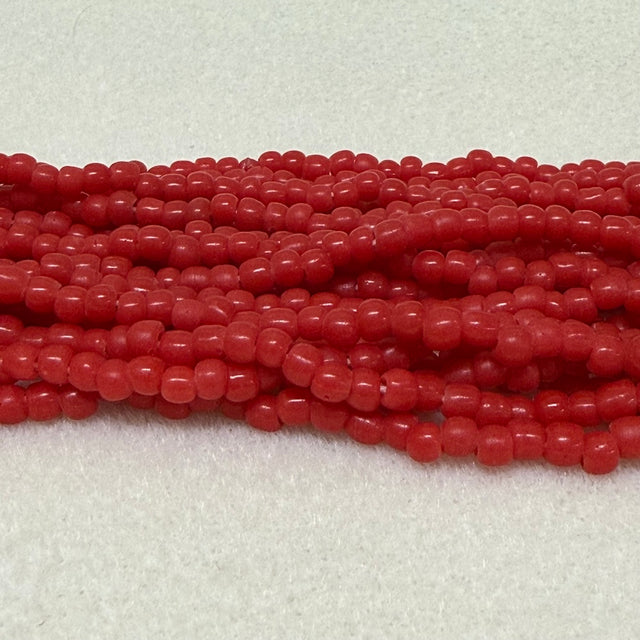 Strings of red round beads on a light gray background