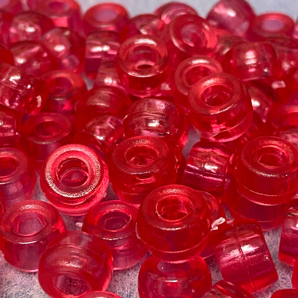 Close-up of rose pink plastic beads on a gray surface