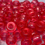 Close-up of rose pink plastic beads on a gray surface