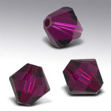 Three purple faceted beads on a gray background