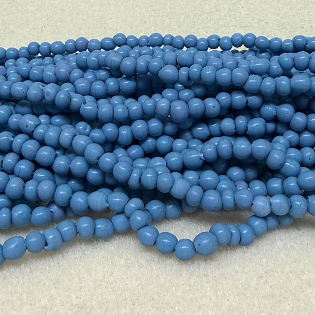 Strings of blue round beads on a light gray background