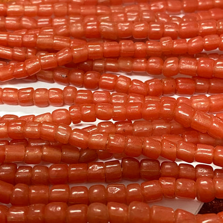 Close-up of orange tube glass beads on a white background