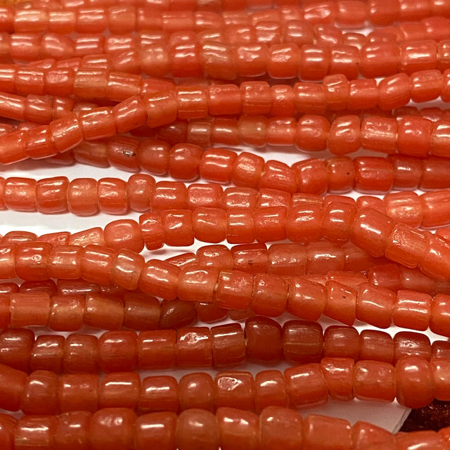 Close-up of orange tube glass beads on a white background